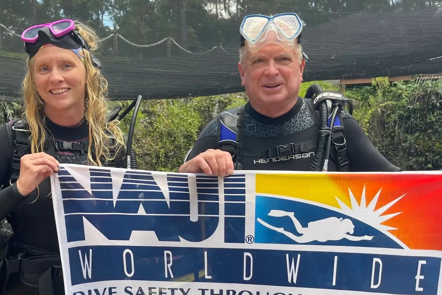 A group of divers holding a NAUI Worldwide banner at Blue Grotto.