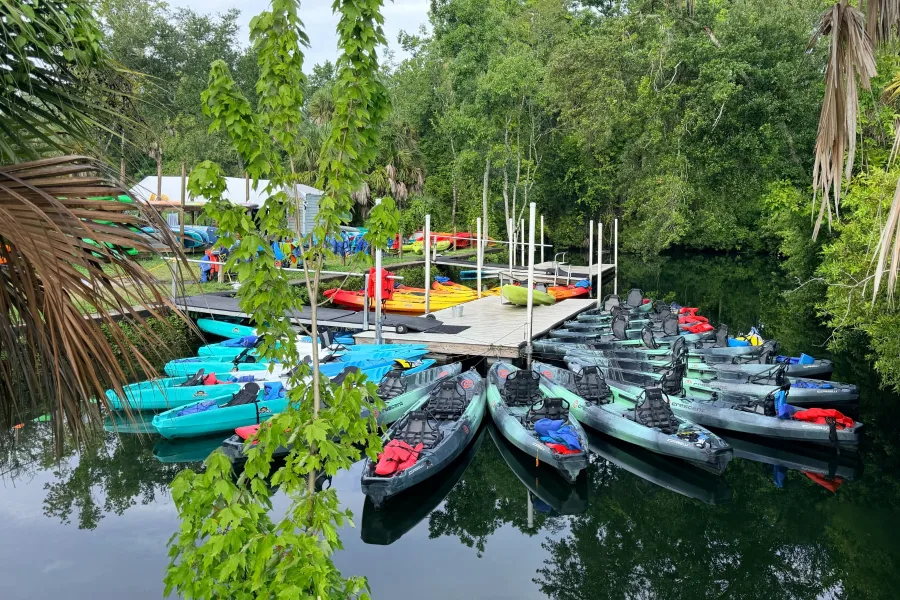 Rental kayaks gathered around the canal dock at Crystal River Kayak Company & Dive Center.