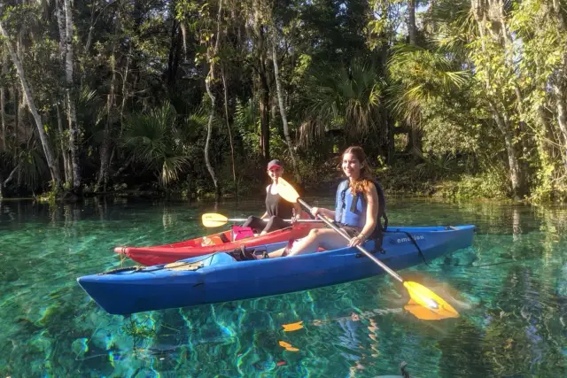 Kayakers paddling together on clear spring water.